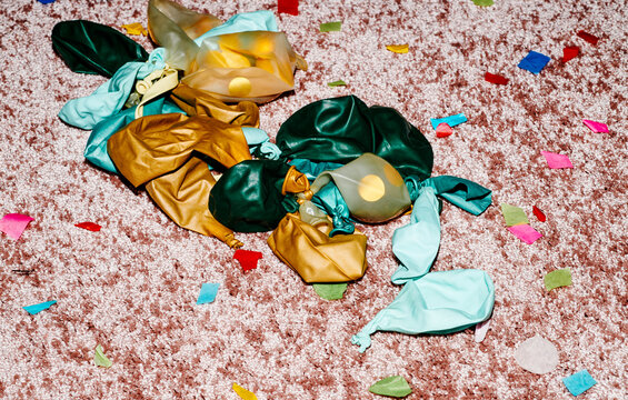 confetti and deflated balloons on a pink carpet