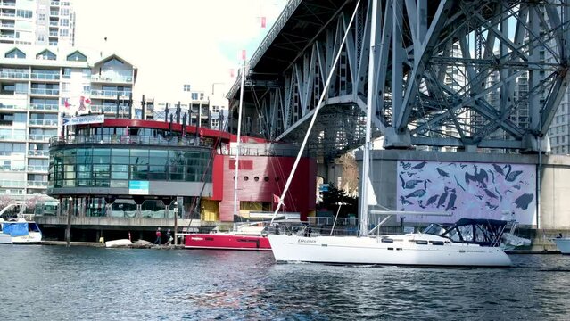 Bridge to greenville and water bus passing under the bridge Nature Canada Vancouver Pacific Ocean Pier and pillars on the pier Granville Island aquabus Skyscrapers in the background 2023 Canada