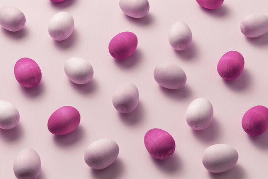Handicraft duotone pink colored wooden eggs.