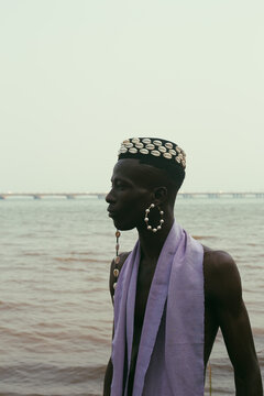  model wearing a hat filled with cowries shells