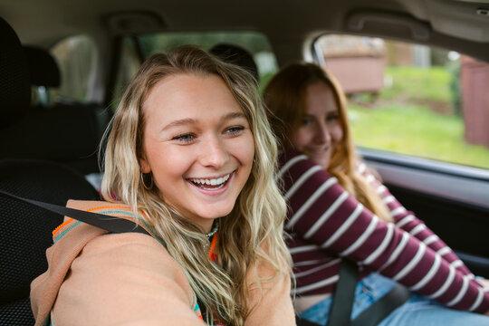 Charming girl friends traveling by car 
