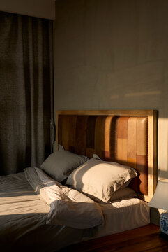 Comfortable big bed in bedroom with morning sun shining in