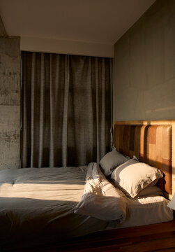 Comfortable big bed in bedroom with morning sun shining in