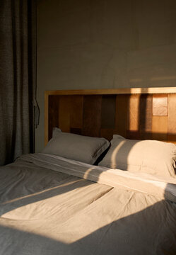 Comfortable big bed in bedroom with morning sun shining in