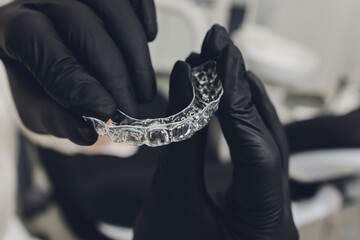 Close-up Of A Woman's Hand Putting Transparent Aligner In Teeth.