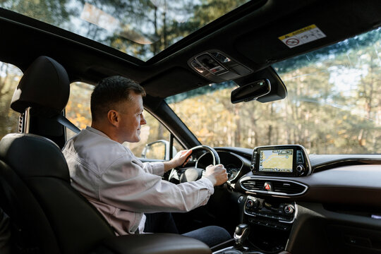 A man uses a navigator while driving a car