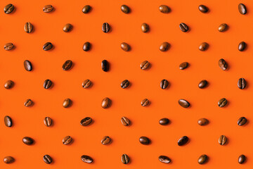 Overhead view of coffee beans on orange background