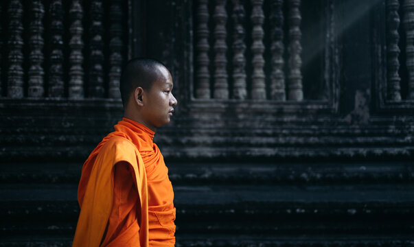 Close-up of a Buddhist monk walking through the Angkor Wat temple