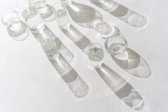 Sunlight falls at glasses of water on light background
