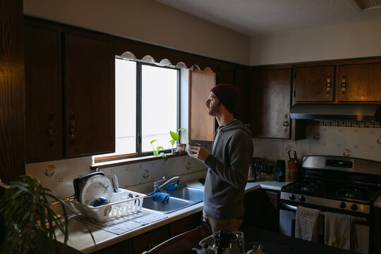 Man drinking coffee in retro kitchen.