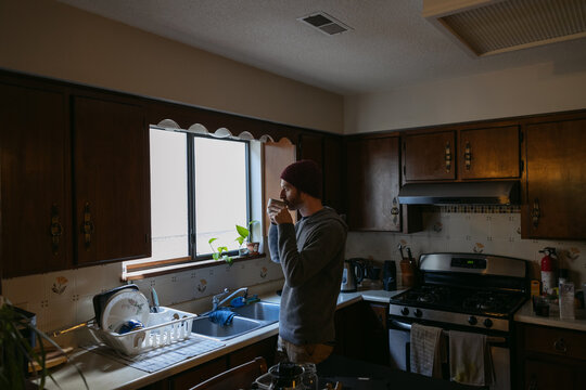 Man drinking coffee in retro kitchen.