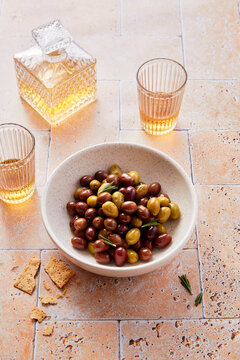 High Angle View of Bowl of Mixed Olives with Glasses of Grappa