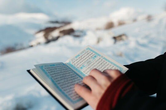man scrolling through Quran