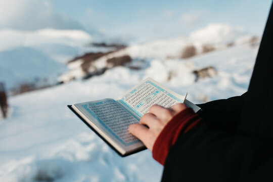 man scrolling through Quran