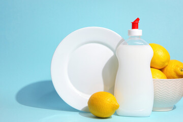 Dishwashing detergent and lemons on a colored background