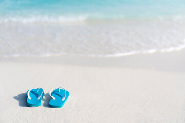 Fototapeta na wymiar Flip flops on the beach on the background of ocean in the Maldives. Beach vacation