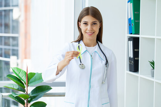 Green ribbon in hand as a symbol to awareness Lymphoma cancer