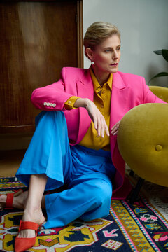 Beautiful 50 year old woman in fashionable suit posing in the interior