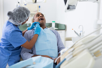 Obraz premium Dentist operates on patient - removes a bad tooth