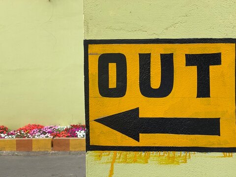 Out with sign is written on the wall of a building