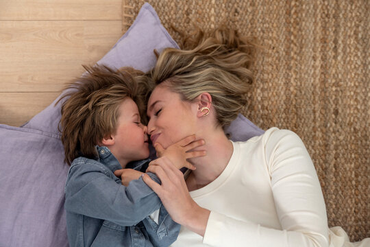 Mother and son lie on the floor embracing