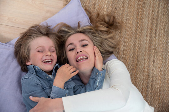 Mother and son lie on the floor embracing