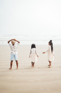 Siblings running on the beach on a foggy day