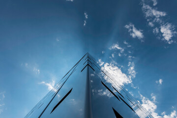 Contemporary building with the sky and clouds reflecting on it 