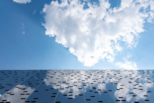  Modern building with the sky and clouds reflecting on its facade 