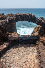 An arch of volcanic stones in the sea on the Verodal beach on El Hierro Island. Canary Islands