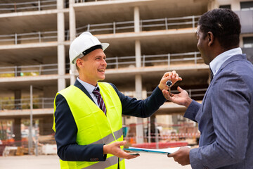 Happy architect transmits keys to the new african american businessman shopping center