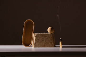 still life of architectural shapes in dramatic light with palo santo