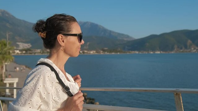 Beautiful female tourist enjoys the seascape.