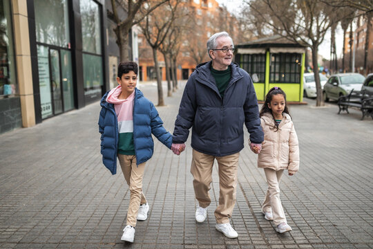 grandfather with grandchildren walking around the city
