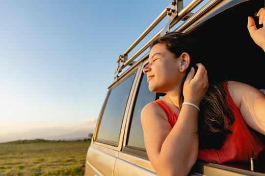 woman sticking her head out of a vehicle window 