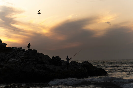 Fisherman fishing at sunset