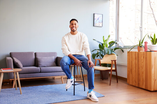 Positive black man sitting on bar stool