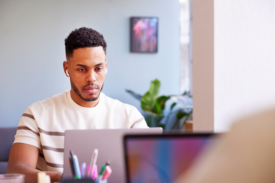 Serious black man working on laptop