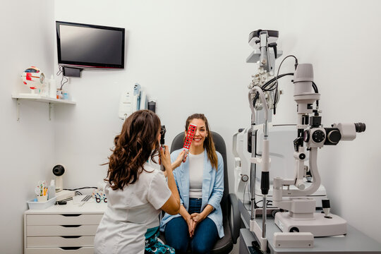 Optometrist checking patient eyes with retinoscope