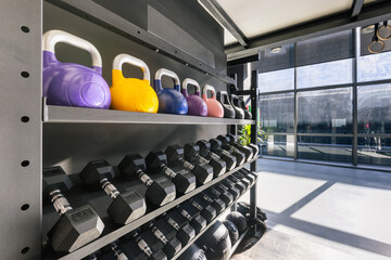 Gym metal rack with a set of dumbbells, kettlebells and exercise balls