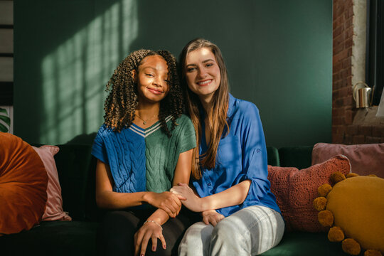 two friends sitting on green sofa 