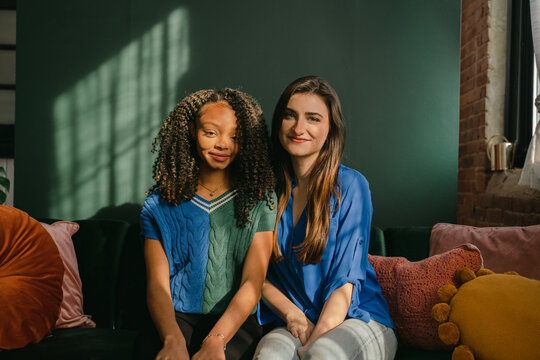 two friends sitting on green sofa 