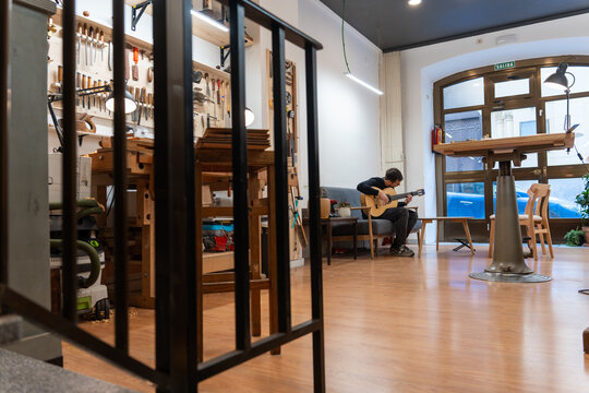 Luthier, Playing The Spanish Guitar In His Workshop. 