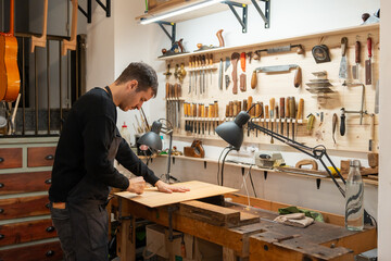 Luthier, Guitar Maker, Working In The Workshop. 
