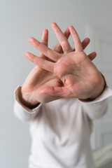Woman showing stop gesture with hand at home. Abuse, mental health, toxic relationship problem.