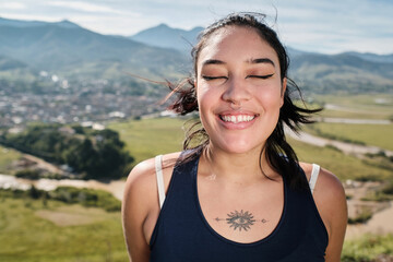 Smiling young latina with her eyes closed