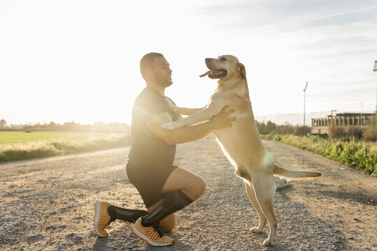 young latino man with labrador retriever dog outdoors