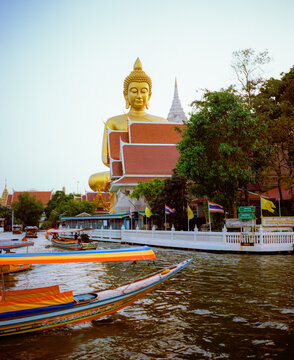 Boats near the high golden statue of Buddha in Bangkok