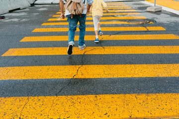 Anonymous Man and kid crossing pedestrian cross 