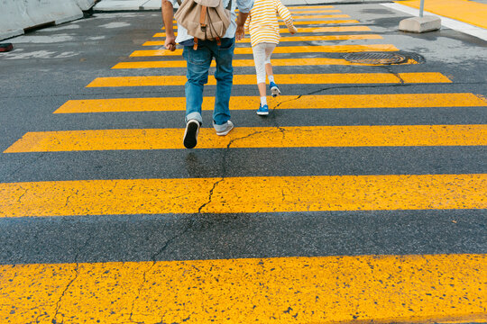 Anonymous Man and kid crossing pedestrian cross 